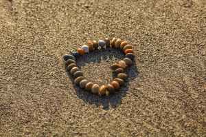 brown and grey stone formed heart on sand